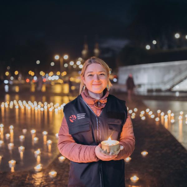 Estonian Refugee Council's employee holding a candle during an event marking 1000 days from the start of a full-scale war in Ukraine
